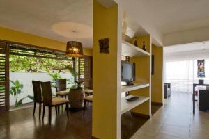 uma sala de estar com uma mesa de jantar e uma televisão em Casa Surucuá com localização espetacular frente à Praia do Centro de Pipa - 2 a 4 quartos suite em Pipa