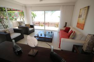 uma sala de estar com um sofá e uma mesa em Casa Surucuá com localização espetacular frente à Praia do Centro de Pipa - 2 a 4 quartos suite em Pipa
