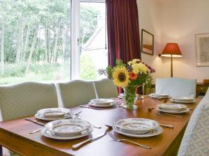 a table with plates and a vase of flowers on it at Eastertown in Marnoch