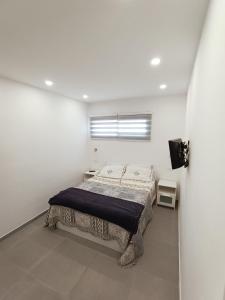 1 dormitorio con 1 cama en una habitación blanca en Mareverde Apartment Pool View, en Adeje