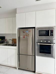 a kitchen with a stainless steel refrigerator and a microwave at Cosway Residence near Pavilion KL in Kuala Lumpur