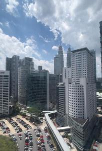 a city skyline with cars parked in a parking lot at Cosway Residence near Pavilion KL in Kuala Lumpur