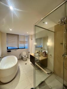 La salle de bains est pourvue d'une grande baignoire et de toilettes. dans l'établissement Cosway Residence near Pavilion KL, à Kuala Lumpur