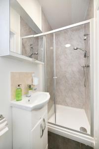 a white bathroom with a shower and a sink at Waylen Street Suites in Reading