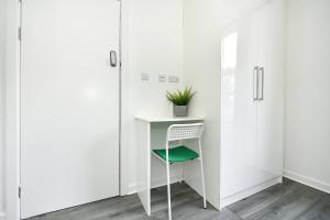 a white desk with a green chair in a room at Waylen Street Suites in Reading