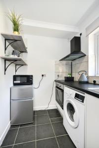 a kitchen with a washing machine and a dishwasher at Laud Close Guest Suites in Reading