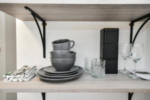 a table with plates and wine glasses on a shelf at Laud Close Guest Suites in Reading