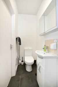 La salle de bains blanche est pourvue de toilettes et d'un lavabo. dans l'établissement Waylen Street Suites, à Reading