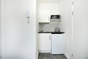 a white kitchen with a sink and a microwave at Waylen Street Suites in Reading