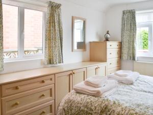 a bedroom with a bed and a dresser and a window at The Cottage in Bridlington