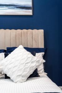a bed with a white comforter and a blue wall at Modern Apartment in Brighton City centre in Brighton & Hove