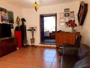 een woonkamer met een bank en een televisie bij Casona Mollepata in Mollepata