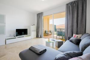 a living room with a couch and a tv at Residencial Playa de La Arena in Puerto de Santiago