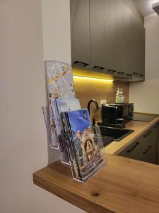 une pile de livres sur un comptoir dans une cuisine dans l'établissement Duga Apartmani 1, à Subotica