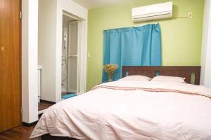 ein Schlafzimmer mit einem großen Bett mit einem blauen Vorhang in der Unterkunft 庵・花園北 in Osaka