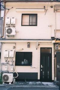 ein Gebäude mit zwei nebenstehenden Klimaanlagen in der Unterkunft 庵・花園北 in Osaka