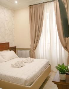 ein Schlafzimmer mit einem weißen Bett und einem Fenster in der Unterkunft Esposizione Boutique in Rom