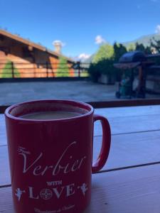 una taza de café roja sobre una mesa de madera en Verbier Medran apartment, en Verbier