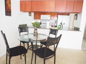 a kitchen with a glass table with chairs and a vase with flowers at x brickel2 in Miami