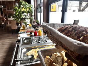 a kitchen with a stove with a tray of bread at Hotel Žabčice in Žabčice