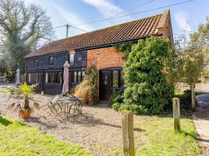 a brick house with a table and chairs in front of it at Pass the Keys The Stable in Norwich