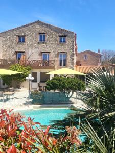 a house with a swimming pool in front of a building at Auberge Du Roua in Argelès-sur-Mer