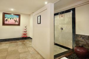 a bathroom with a walk in shower next to a toilet at Vila Ombak in Gili Trawangan