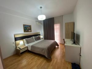 a bedroom with a bed and a flat screen tv at Rooms Dionis in Tirana