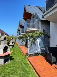 a house with a yard with chairs and a patio at Jastrzębia Marina - komfortowe całoroczne domki in Jastrzębia Góra