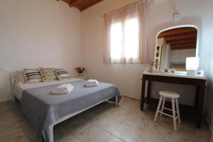1 dormitorio con cama, tocador y espejo en Villa Rouvis with outdoor Hot Tub, en Ligaridia