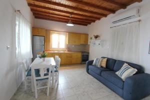 - un salon avec un canapé bleu et une table dans l'établissement Villa Rouvis with outdoor Hot Tub, à Ligaridia