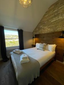 a bedroom with a large bed with towels on it at The Queen Matilda Country Rooms in Tetbury