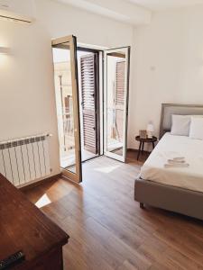 a bedroom with a bed and two sliding glass doors at M. Szwed. Guest House old Bari in Bari