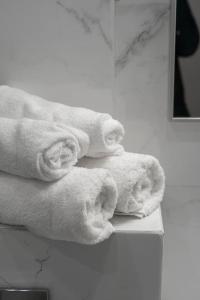drie handdoeken worden gestapeld op een plank in een badkamer bij RentWill apartments Clouds in Chişinău