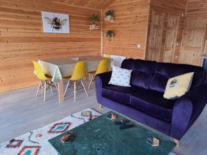 uma sala de estar com um sofá roxo e uma mesa em Nature's Nook - Norfolk Broads em Brundall
