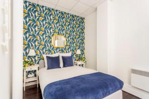 um quarto com uma parede estampada em azul e amarelo em Cosy 3 bedrooms apartment with bathrooms - Louvre em Paris