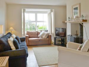 a living room with a couch and a tv at Little Stretton in Bigbury on Sea