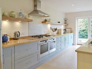 a kitchen with white cabinets and a counter top at Little Stretton in Bigbury on Sea