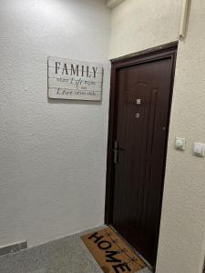 a brown door with a family sign on the wall at Family Apartment in Niš