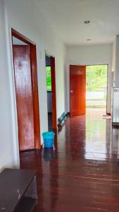 an empty living room with a wooden floor and doors at Happy Garden in Kampong Tenompok