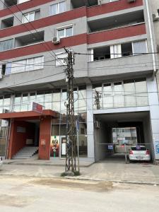 a large building with a parking lot with a car in it at Family Apartment in Niš
