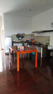 a kitchen with a table in the middle of a room at Happy Garden in Kampong Tenompok