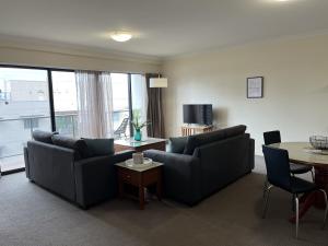 a living room with two couches and a table at 501 Sky High Cbd Style With Parkingpool in Perth