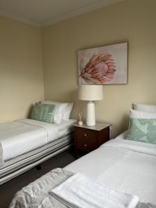 1 dormitorio con 2 camas y mesa con lámpara en 501 Sky High Cbd Style With Parkingpool en Perth