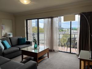sala de estar con sofá y mesa en 501 Sky High Cbd Style With Parkingpool en Perth