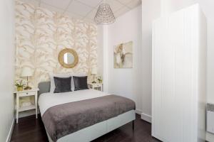 um quarto branco com uma cama e um espelho em Cosy 3 bedrooms apartment with bathrooms - Louvre em Paris