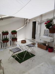 un tavolo e due sedie in una stanza con piante di La Casetta a Palermo