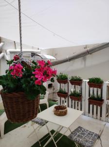 un balcone con fiori in cestini e un tavolo di La Casetta a Palermo