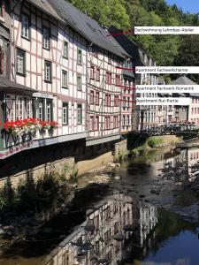 un bâtiment avec un pont sur une rivière dans l'établissement An der Rur - 4 Apartments mitten in Monschau, à Monschau