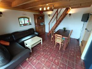 ein Wohnzimmer mit einem Sofa und einem Tisch in der Unterkunft Boerderij De Vrije Geest in Toldijk